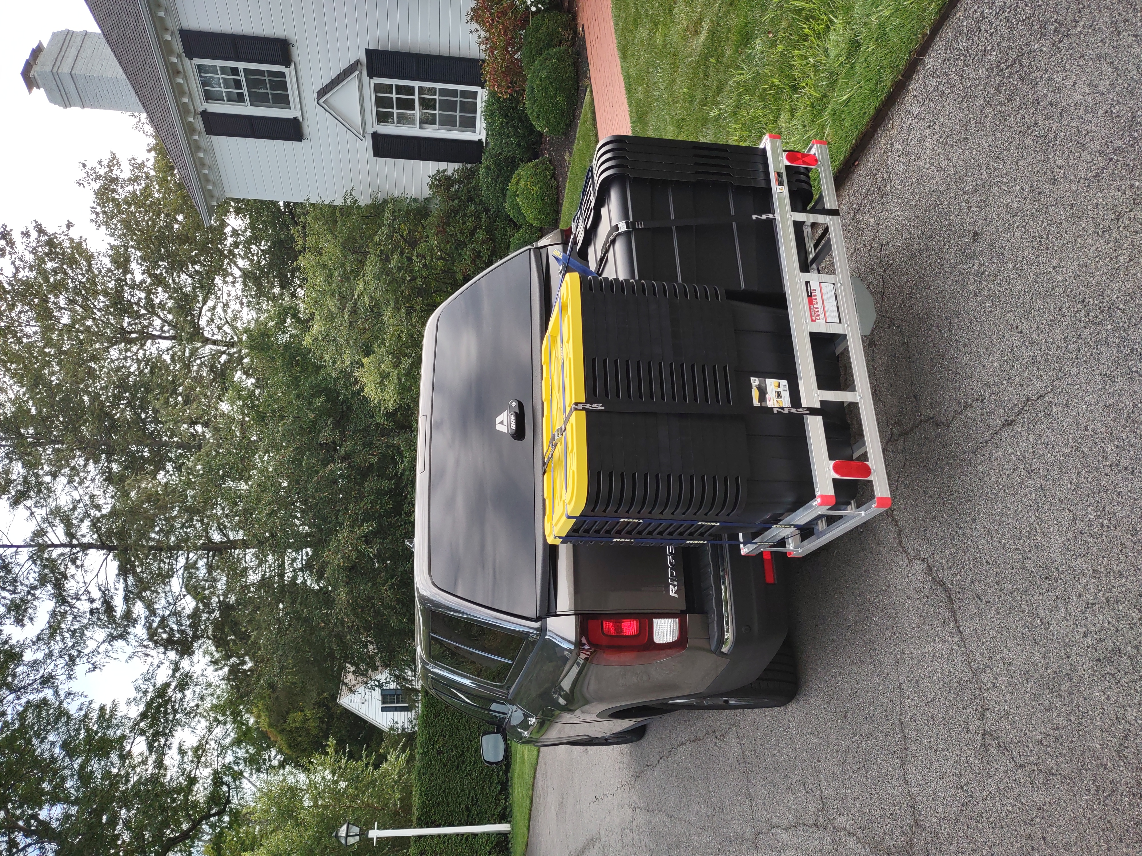 Stack of reusable moving totes loaded and strapped down on a truck cargo carrier, ready for delivery in Buffalo NY